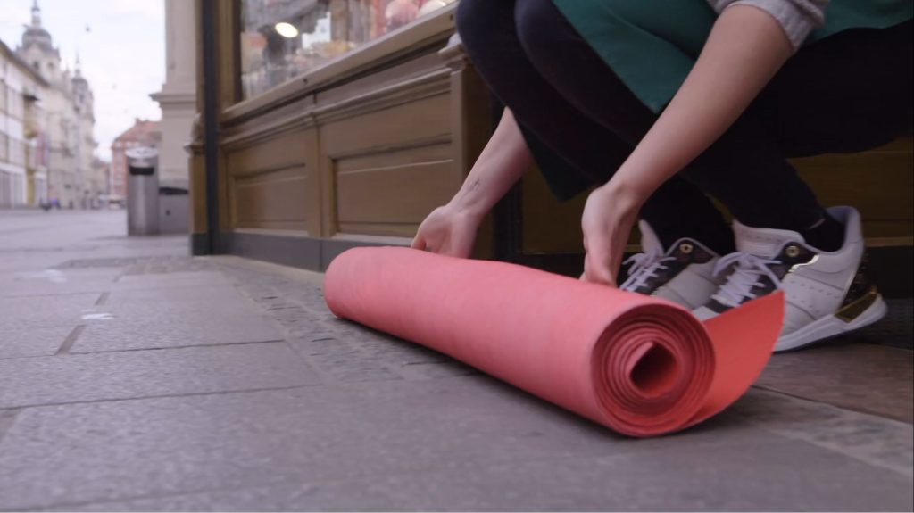 Frau rollt roten Teppich aus