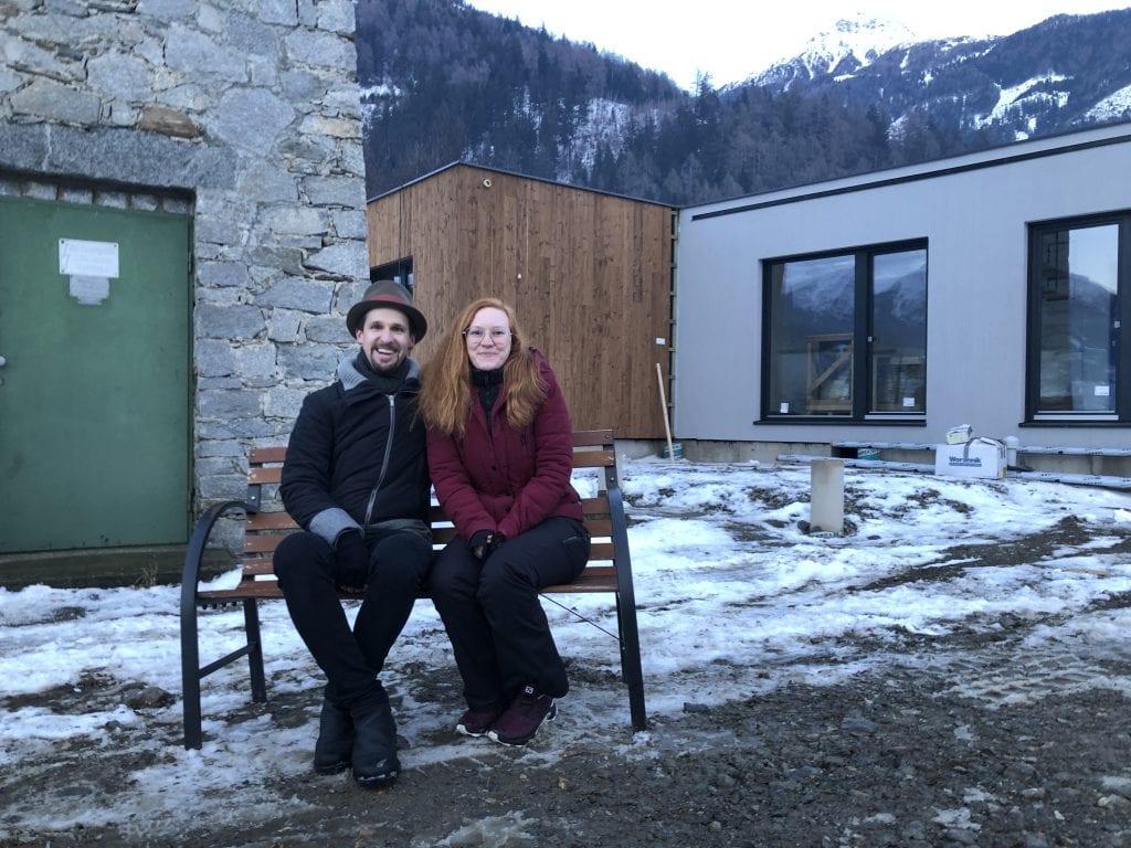 Raphaela und Dominik sitzen vor ihrem fertig aufgestellten Haus